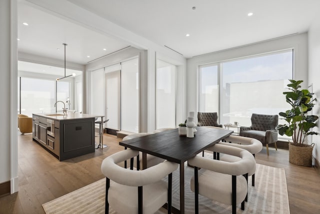 dining area featuring light wood-type flooring and sink