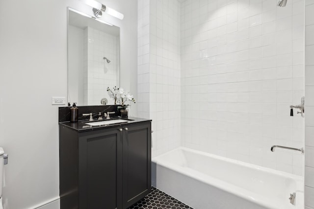 bathroom with tiled shower / bath combo, tile patterned flooring, and vanity