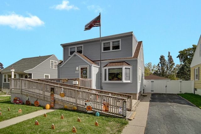 rear view of house featuring a wooden deck and a yard