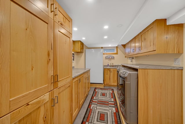 kitchen featuring white fridge, stove, and light brown cabinetry