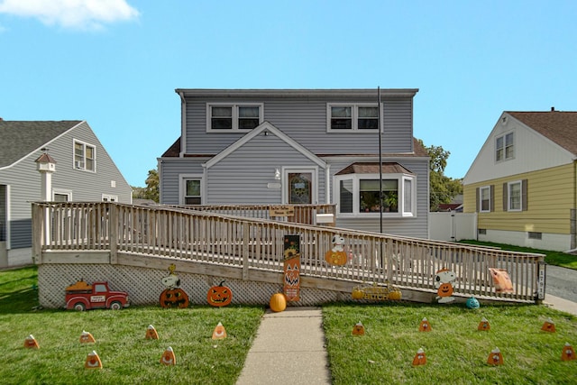 rear view of house with a wooden deck and a lawn