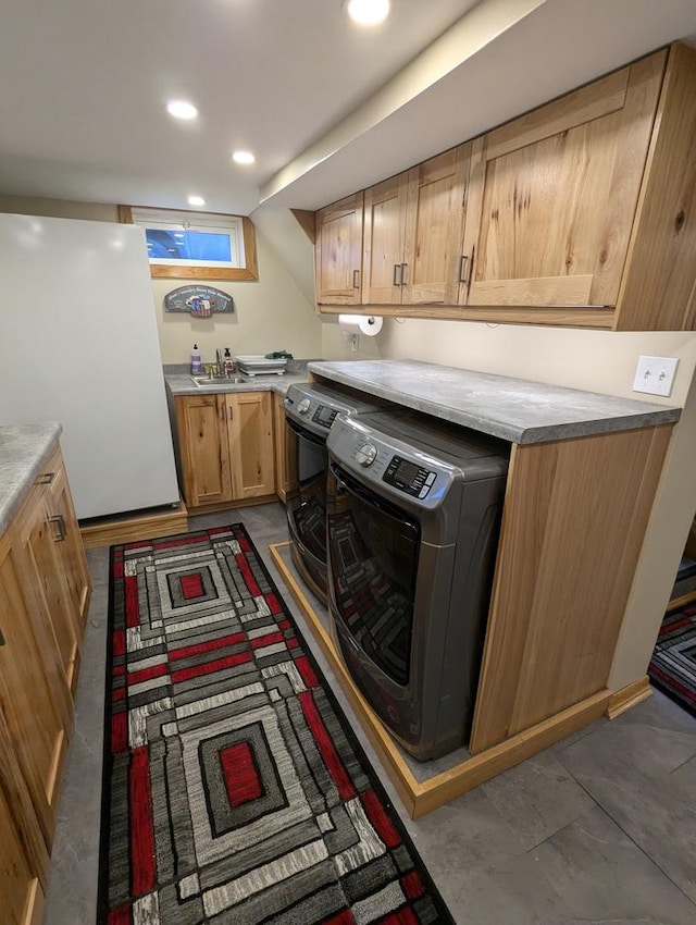 laundry area featuring cabinets, washer and dryer, and sink