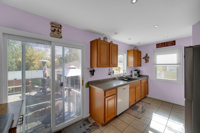 kitchen with sink, stainless steel fridge, light tile patterned floors, and dishwasher