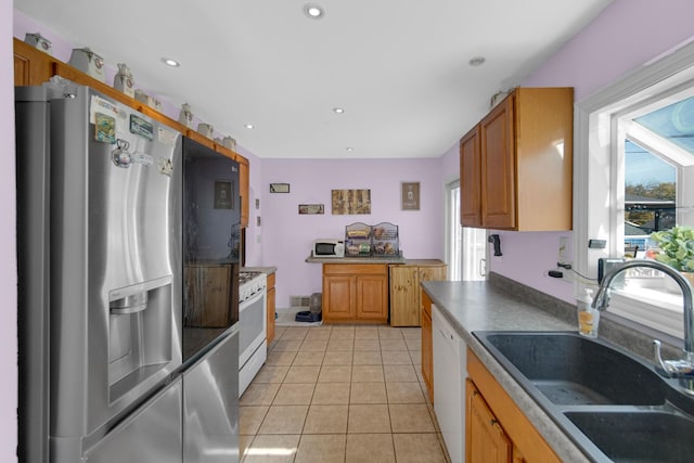 kitchen featuring light tile patterned floors, sink, and white appliances