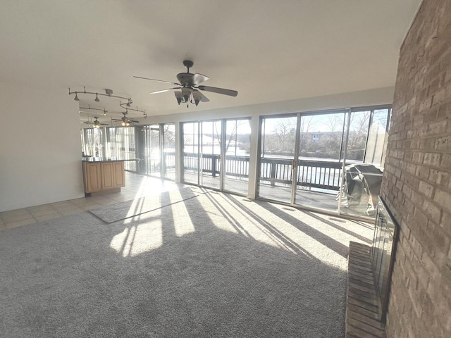 interior space featuring ceiling fan, a wealth of natural light, and a water view