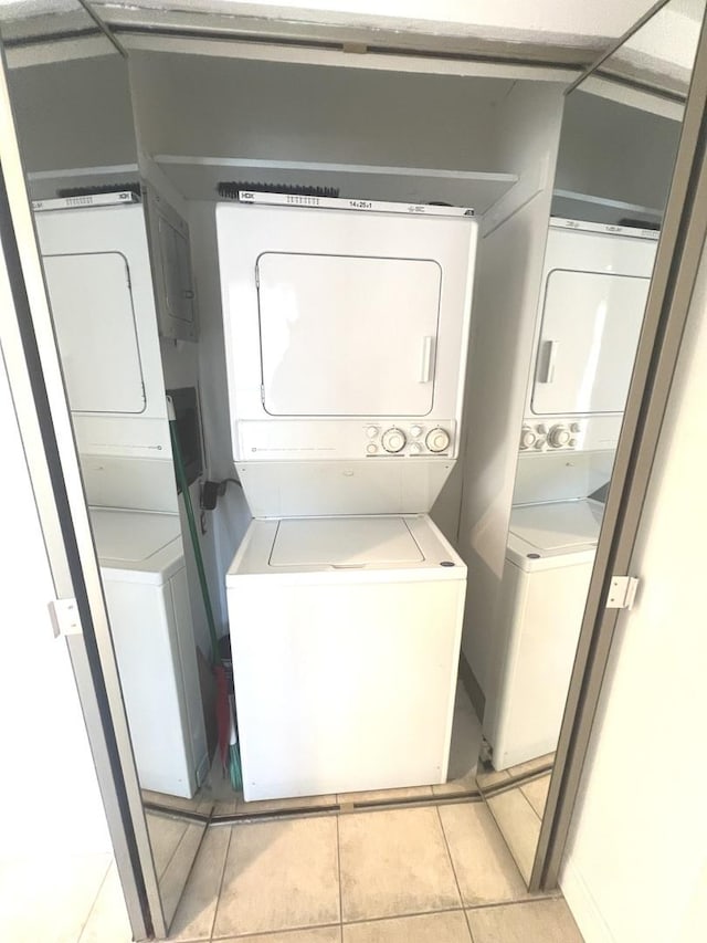 laundry room with light tile patterned floors and stacked washing maching and dryer