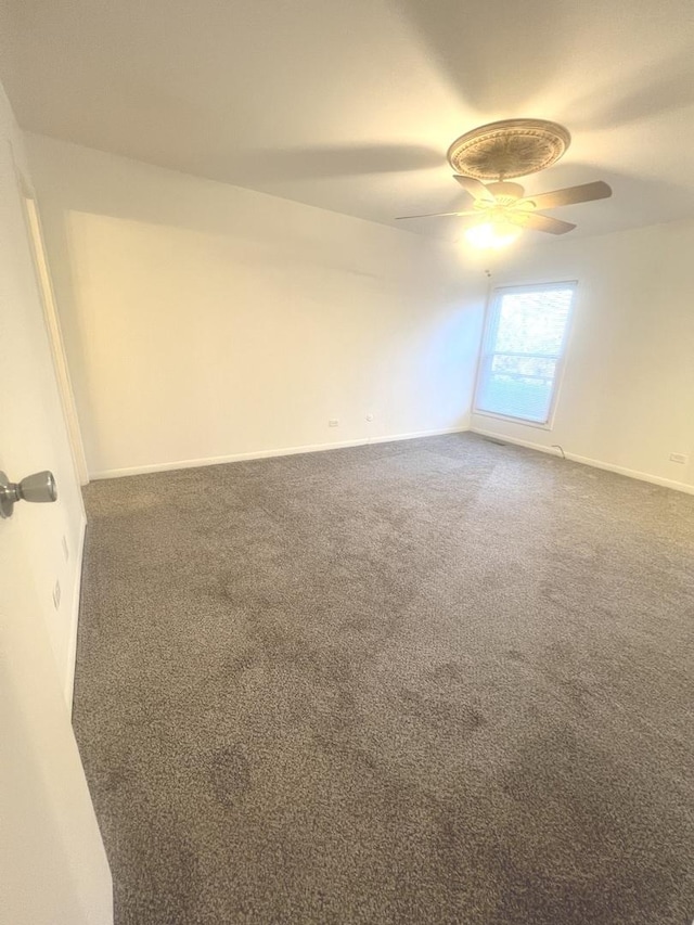 carpeted spare room with ceiling fan