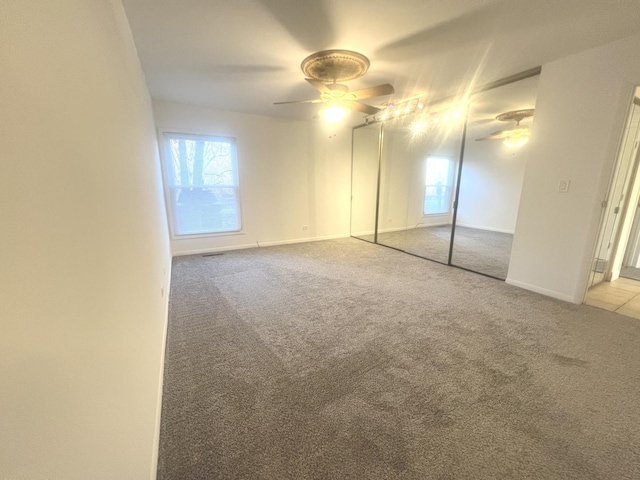 unfurnished bedroom featuring light carpet and ceiling fan