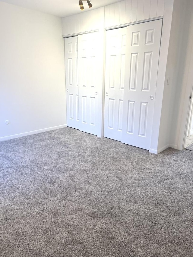 unfurnished bedroom featuring multiple closets and carpet