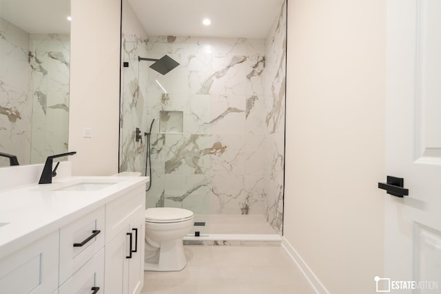 bathroom with toilet, vanity, tile patterned floors, and a tile shower