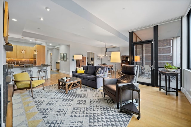 living room with light hardwood / wood-style floors and a wall of windows