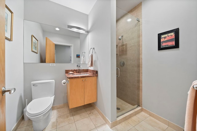 bathroom with tile patterned flooring, vanity, a shower with shower door, and toilet