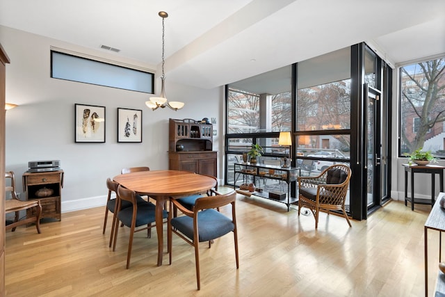 dining space with a chandelier and light wood-type flooring