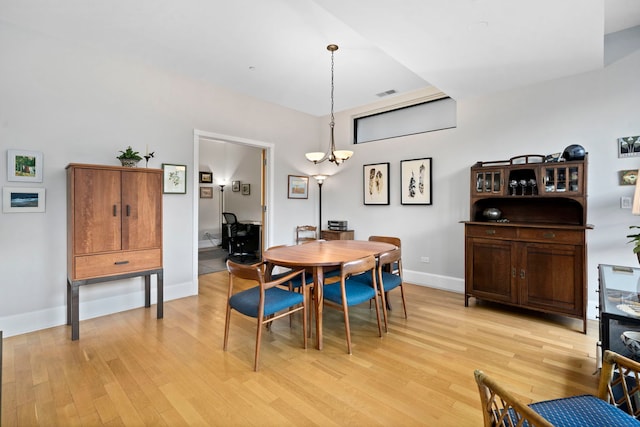 dining space featuring a chandelier and light wood-type flooring