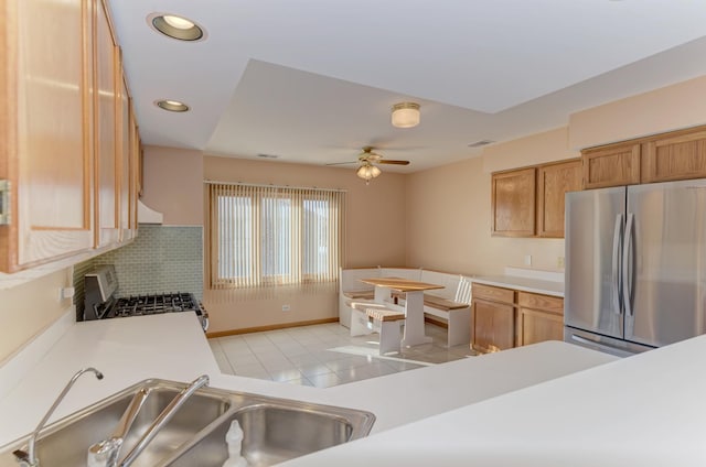 kitchen featuring light tile patterned floors, recessed lighting, a sink, light countertops, and appliances with stainless steel finishes