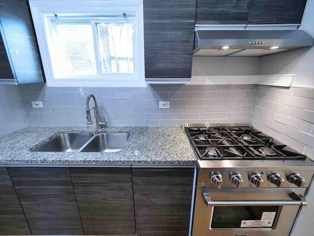 kitchen with decorative backsplash, range hood, dark brown cabinets, and stainless steel range with gas stovetop