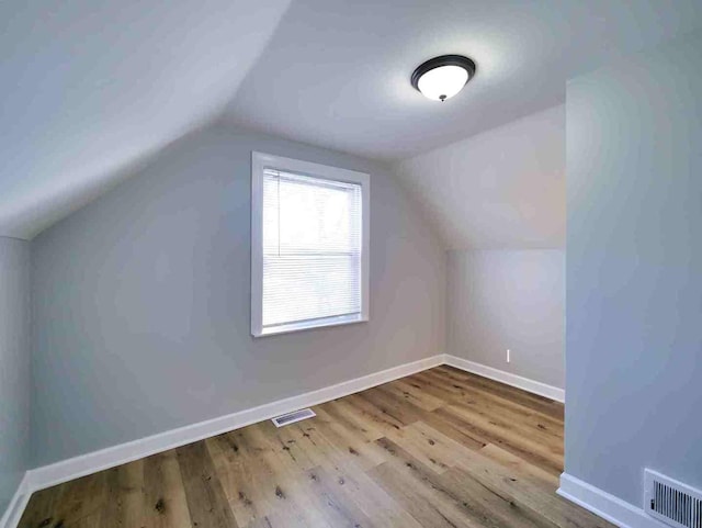 additional living space featuring lofted ceiling and light hardwood / wood-style flooring