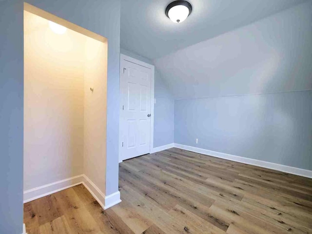 bonus room with vaulted ceiling and hardwood / wood-style flooring