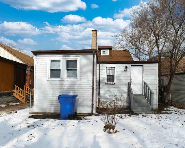 view of snow covered rear of property