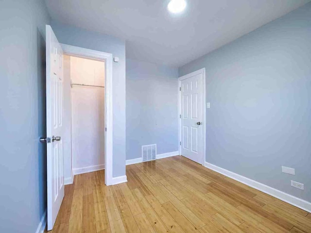 unfurnished bedroom featuring light hardwood / wood-style floors and a closet