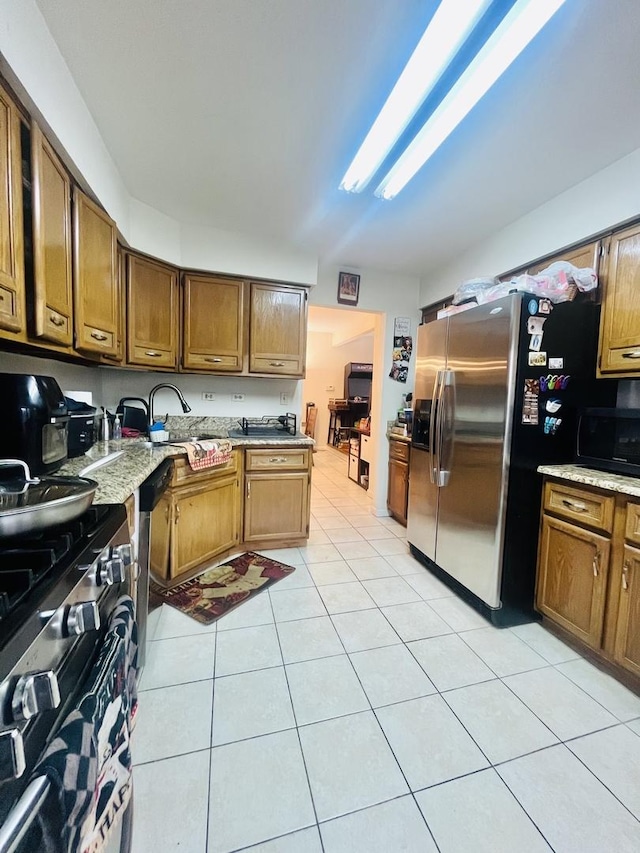 kitchen featuring sink, light tile patterned floors, and stainless steel appliances