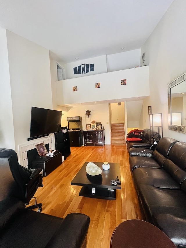 living room featuring hardwood / wood-style flooring and a towering ceiling