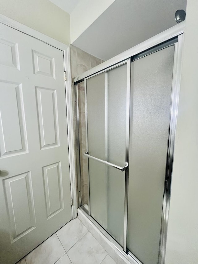 bathroom with tile patterned floors and a shower with shower door