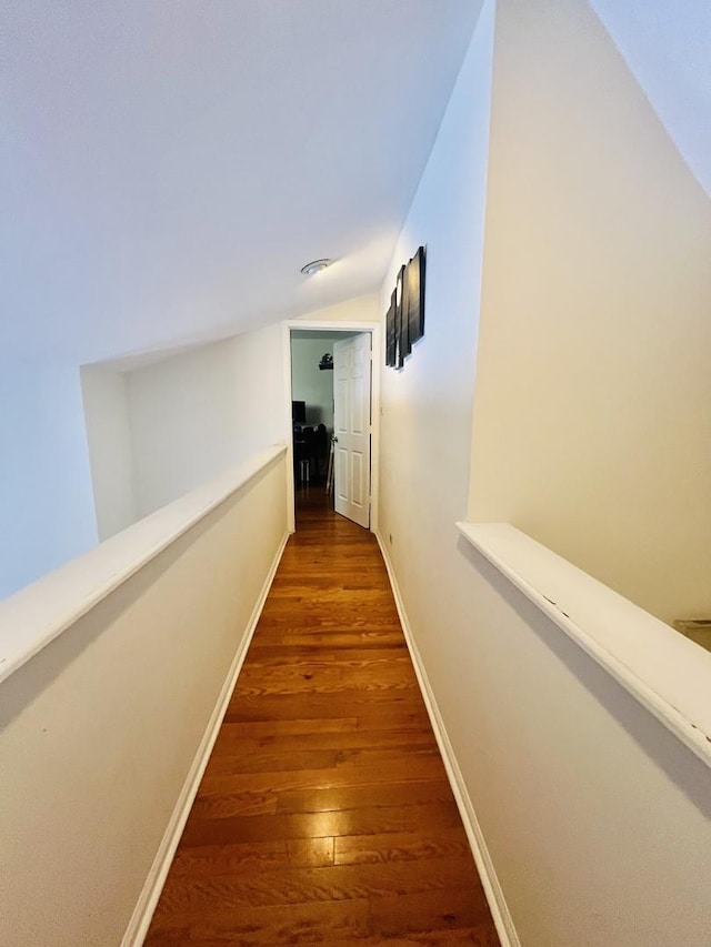 hallway featuring lofted ceiling and dark hardwood / wood-style floors