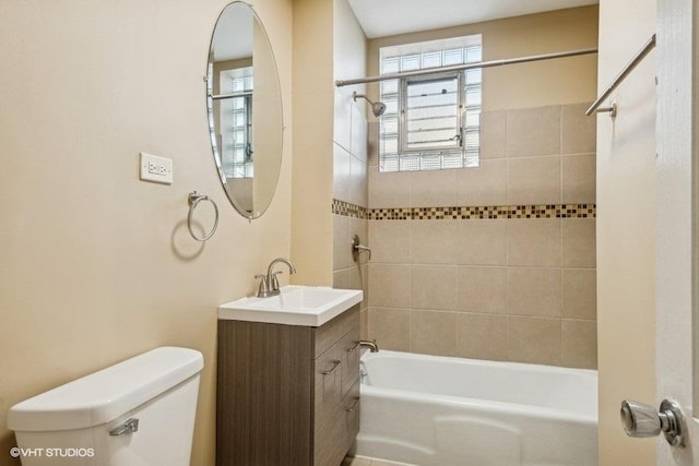 full bathroom with vanity, tiled shower / bath combo, a wealth of natural light, and toilet