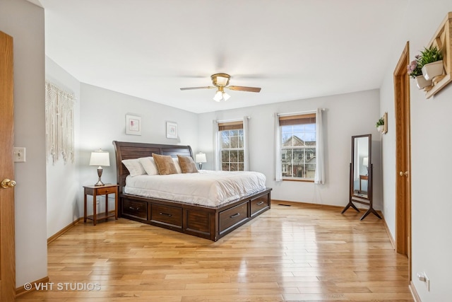 bedroom with light wood-type flooring, ceiling fan, and baseboards