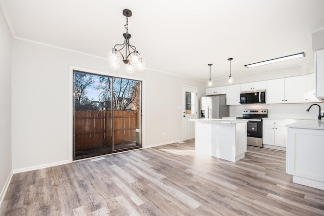 kitchen featuring hanging light fixtures, white cabinets, stainless steel appliances, and a kitchen island