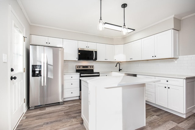 kitchen featuring a kitchen island, decorative backsplash, hanging light fixtures, appliances with stainless steel finishes, and white cabinets