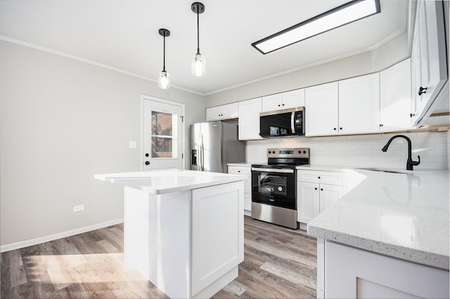 kitchen featuring hanging light fixtures, white cabinets, appliances with stainless steel finishes, and sink