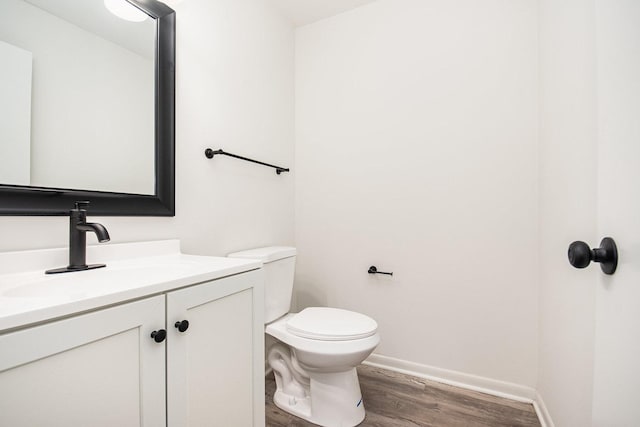 bathroom with toilet, wood-type flooring, and vanity