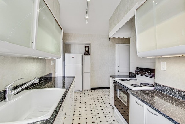 kitchen featuring rail lighting, sink, range with electric stovetop, white fridge, and white cabinets