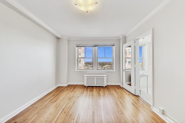 empty room with ornamental molding, radiator, and light wood-type flooring