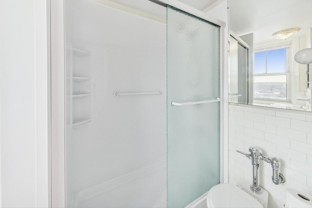 bathroom with an enclosed shower and toilet