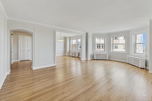 unfurnished living room featuring radiator, ornamental molding, and light hardwood / wood-style floors