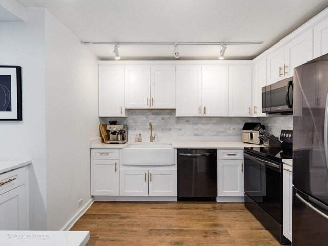 kitchen with sink, white cabinets, and black appliances