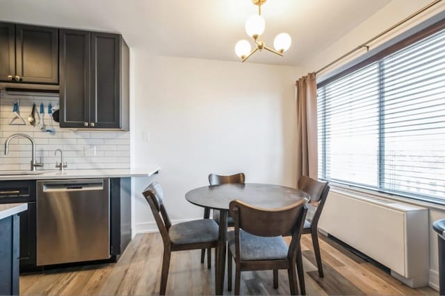 dining room featuring an inviting chandelier, light hardwood / wood-style flooring, and sink