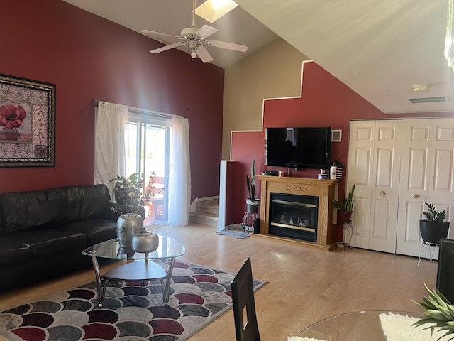 living room featuring ceiling fan, lofted ceiling, and light hardwood / wood-style flooring