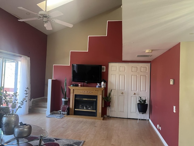 living room with light hardwood / wood-style floors, lofted ceiling, and ceiling fan