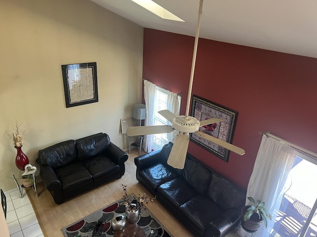 living room with a skylight and high vaulted ceiling