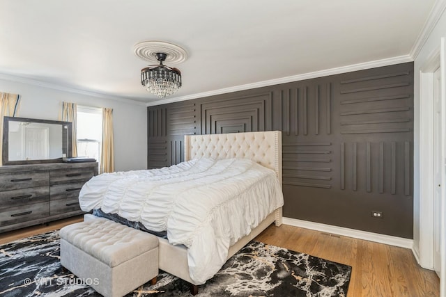 bedroom featuring hardwood / wood-style flooring, a chandelier, and ornamental molding