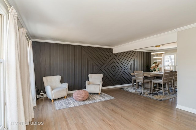 living area featuring wood-type flooring and ornamental molding