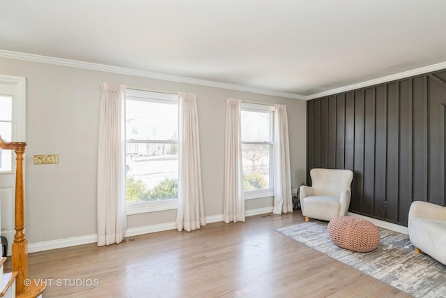 living area with crown molding and light wood-type flooring