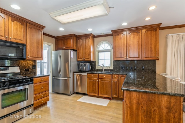 kitchen featuring sink, light hardwood / wood-style flooring, appliances with stainless steel finishes, and decorative backsplash