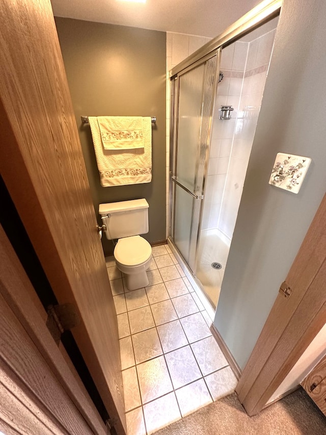 bathroom with toilet, tile patterned flooring, and an enclosed shower