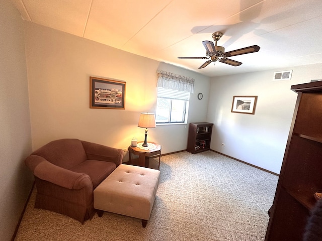 living area featuring ceiling fan and carpet