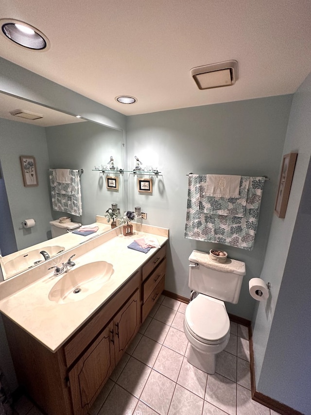 bathroom with toilet, tile patterned flooring, and vanity